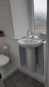 a white bathroom with a sink and a toilet at GWR Dickson's House, NC500, Wick in Wick