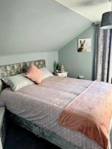 a bedroom with a large bed with pink pillows at GWR Dickson's B&B in Wick