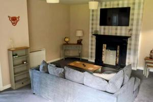 a living room with a couch and a fireplace at GWR Dickson's House, NC500, Wick in Wick +13 photos