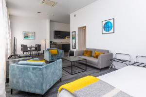 a living room with a couch and chairs and a table at Quest Invercargill Serviced Apartments in Invercargill