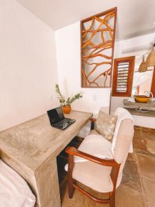 a room with a desk with a laptop and a chair at Pousada Fortal Preá in Prea