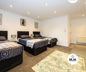1 dormitorio con 3 camas en una habitación en The Westbourne Short-Stay en Ince-in-Makerfield