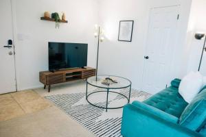 ein Wohnzimmer mit einem blauen Sofa und einem Glastisch in der Unterkunft Cozy Apartment a few steps from The Capitol in Salt Lake City