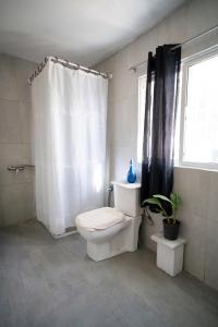 a bathroom with a toilet and a shower curtain at Cozy Home Stay 