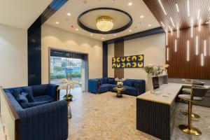 ジャイプールにあるRoyal Rawal - Luxury Boutique Hotelの青いソファとデスクが備わるロビー