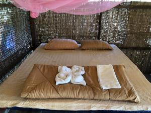 2 Handtücher auf einem Bett in einem Strohzimmer in der Unterkunft The Last Point Koh Takiev in Koh Ta kiev Island