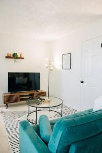 uma sala de estar com um sofá azul e uma mesa em Cozy Apartment a few steps from The Capitol em Salt Lake City