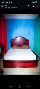a bed with a wooden head board in a room at Hotel Divas in El Remate