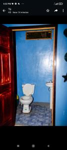 a bathroom with a toilet and a blue wall at Hotel Divas in El Remate