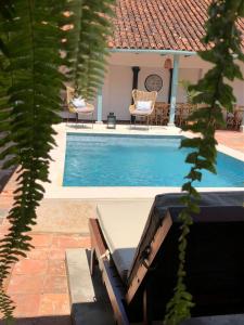 a swimming pool with a table and chairs next to a house at Camino a Santa Fe in Guaduas