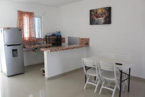 a kitchen with a table and a refrigerator at Casa Rojas, a una calle de la playa! in Progreso