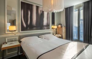 a bedroom with a large white bed and a window at Hotel Litteraire Le Swann, BW Premier Collection in Paris
