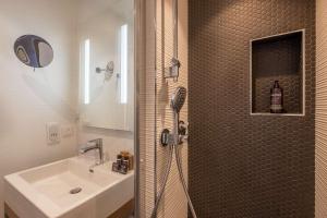 a bathroom with a sink and a shower with a shower at Hotel Litteraire Le Swann, BW Premier Collection in Paris