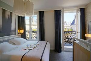 a hotel room with a bed and a large window at Hotel Litteraire Le Swann, BW Premier Collection in Paris