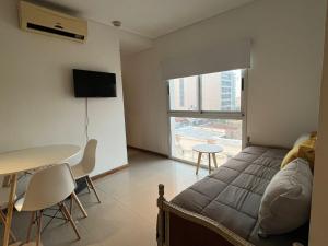 1 dormitorio con cama, mesa y ventana en Departamento céntrico con cochera - Corrientes Capital en Corrientes