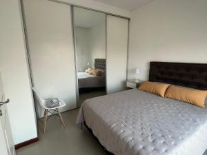 a bedroom with a bed and a mirror at Departamento céntrico con cochera - Corrientes Capital in Corrientes