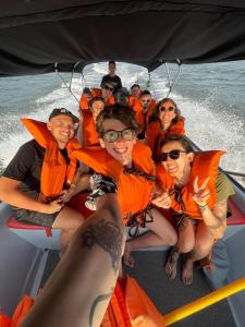 a group of people in orange life jackets on a boat at Social Hostel Café e Bar in Curitiba