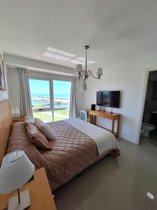 a bedroom with a bed with a view of the ocean at Edificio Juana del Mar in Mar del Plata