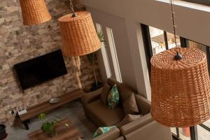 a living room with two large wicker chandeliers at Hermosa casa de campo con piscina en Cieneguilla in Cieneguilla