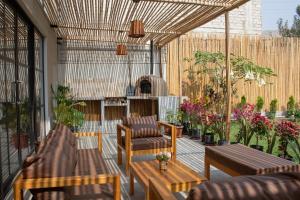 a patio with couches and chairs and plants at Hermosa casa de campo con piscina en Cieneguilla in Cieneguilla