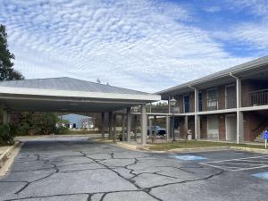 Un estacionamiento vacío frente a un edificio en Motel 6 Sandersville, GA, en Sandersville