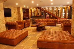 un vestíbulo con muebles de cuero marrón y una escalera en Lujosa Casa Campestre 5 estrellas a 18 min de Cali, en Cali
