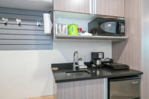 una pequeña cocina con fregadero y microondas en Mountainside Inn 419-21 Hotel Room en Telluride