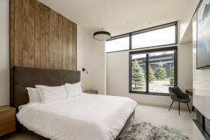 sypialnia z dużym białym łóżkiem i oknem w obiekcie 11 Treeline by Moonlight Basin Lodging w mieście Big Sky