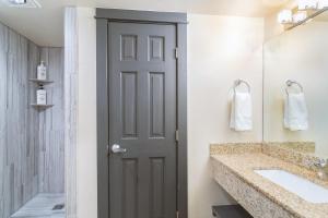 a bathroom with a door and a sink and a mirror at Mountainside Inn 419/421 by Alpine Lodging Telluride in Telluride