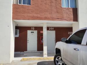 um camião branco estacionado em frente a um edifício em Hotel Suite las Misiones em Ciudad Juárez
