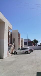 um carro estacionado num parque de estacionamento ao lado de um edifício em Hotel Suite las Misiones em Ciudad Juárez