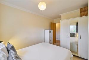 a bedroom with a white bed and a closet at Host & Stay - Nunnery Fields in Canterbury