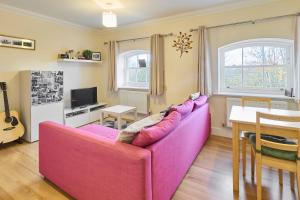 a living room with a pink couch and a table at Host & Stay - Nunnery Fields in Canterbury