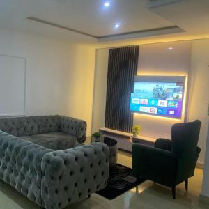 a living room with a couch and a flat screen tv at Ace shortlet apartment in Abuja