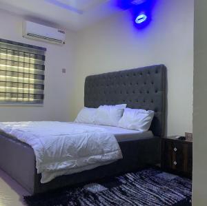 sypialnia z łóżkiem z zagłówkiem w obiekcie Ace shortlet apartment w mieście Abudża