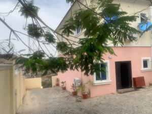 a pink building with plants in front of it at Ace shortlet apartment in Abuja