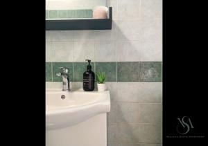 a bathroom with a sink with a bottle of wine on it at Velluto Suite Apartment in Calderara di Reno