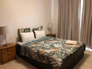 Ocean Dream Apartment في فونشال: غرفة نوم مع سرير وطاولة مع مصباحين