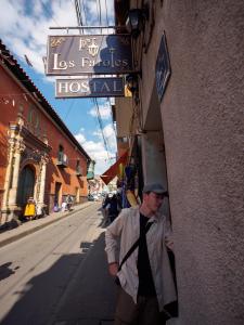 a man in a tie walking down a street at Los Faroles Hostal in Potosí