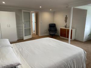 a bedroom with a bed and a desk and a chair at Churchill Oasis by the sea in Tauranga