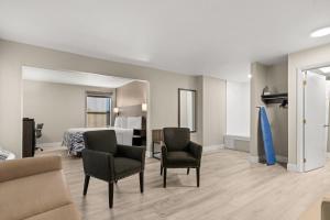 a hotel room with a bed and two chairs at Red Roof Inn Washington, NC in Washington