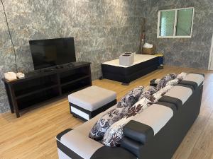 a living room with four couches and a television at Aunty Fou's Home - Vaivase in Apia