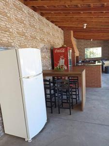 białą lodówkę w pokoju ze stołem i krzesłami w obiekcie Lindo Sítio, Itapeva MG a 120km w mieście Itapeva