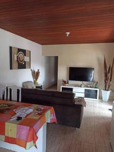salon z kanapą i telewizorem w obiekcie Lindo Sítio, Itapeva MG a 120km w mieście Itapeva