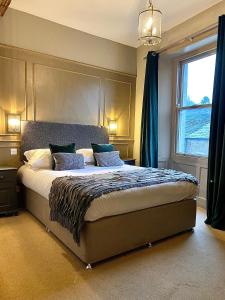 a bedroom with a large bed with blue curtains at The Coach House Skipton in Skipton