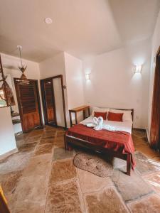a bedroom with a bed with a red blanket at Pousada Fortal Preá in Prea