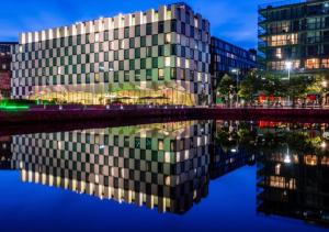 un edificio con su reflejo en el agua por la noche en Luxury Townhouse, en Dublín