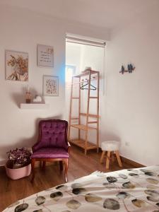 a living room with a purple chair and a ladder at Paraíso a Dois em Estremoz in Estremoz