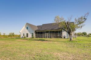 a white barn with a tree in a field at Texas Farmhouse on 5 Acres Patio and Grill! in Manor