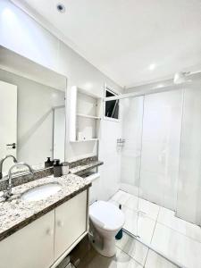 La salle de bains est pourvue de toilettes, d'un lavabo et d'une douche. dans l'établissement AP alto padrão no Caiçara, à Praia Grande